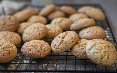 Oatmeal cookies on black metal grille, wooden background. Healthy vegan cookies.