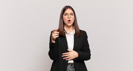 young business woman pointing at camera with an angry aggressive expression looking like a furious, crazy boss