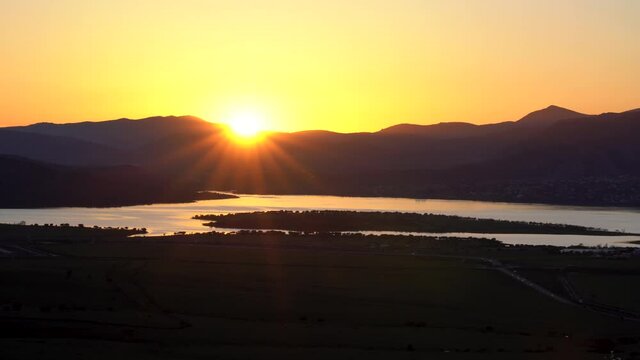 Sunset in the mountains with water lake in the valley and sun rays in the blue sky. Navacerrada Madrid.