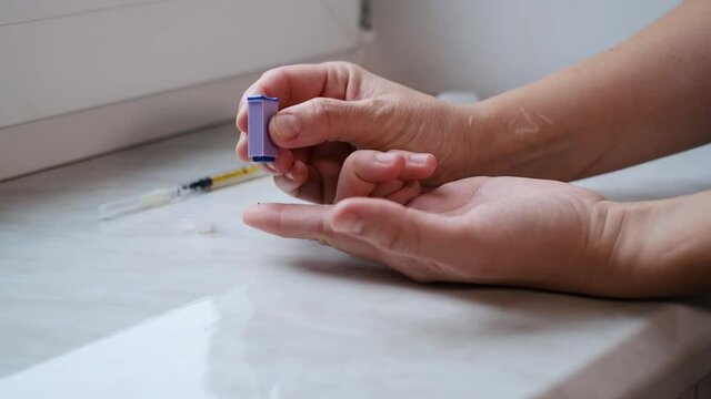 A woman doing a rapid test at home to determine the coronavirus, COVID 19. PatienCovid-19 test kit for the determination of IgM IgG antibodies and immunity in 15 minutes.
