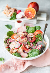 Salmon salad with orange, spinach and radish with ingredient for making salad on wooden cutting board. Healthy food.