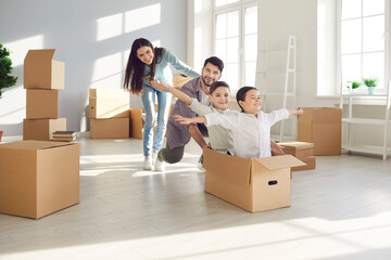 Parents and children moving in. Husband and wife with their children, who are sitting in a...