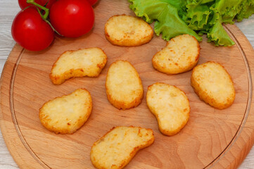 Oven potato pancakes and tomato.food on the plate