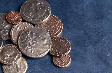 Pile of Ancient Roman Coin Replicas on a Blue Background