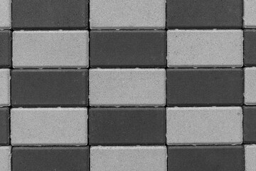 The wall is made of dark and light bricks. Color - Charcoal, Dark Gray.