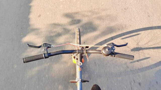 A young bike rider performing stunt on road on bicycle, not holding handle of bicycle in full speed, top view of a bicycle stunt performing by a rider