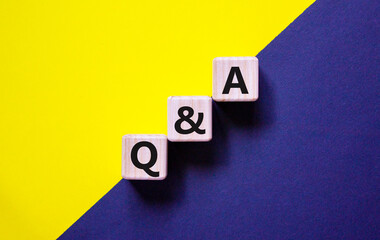 Q and A, questions and answers symbol. Concept words 'Q and A questions and answers' on wooden cubes on a beautiful yellow and black background. Business and Q and A, questions and answers concept.