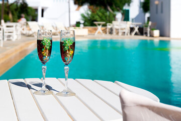 Two glasses with wine on the table. Summer cafe terrace on the beach. Relax by the pool with wine . Vacation time