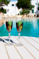 Two glasses with wine on the table. Summer cafe terrace on the beach. Relax by the pool with wine . Vacation time