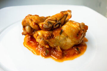 Pollo guisado con salsa de tomate, cebolla y perejil