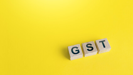 Blocks with letters GST (Goods and Services Tax) on a yellow background. State financial policy to...