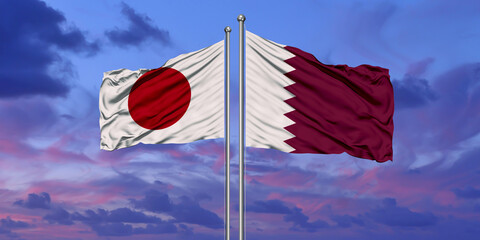 Qatar and Japan two flags on flagpoles and blue cloudy sky