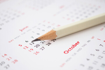 white pencil on calendar background business planning appointment meeting concept