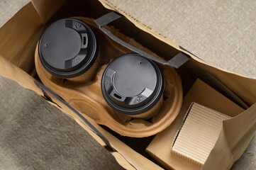 Disposable paper tableware. Coffee cups in holder, cookie carton and paper bag