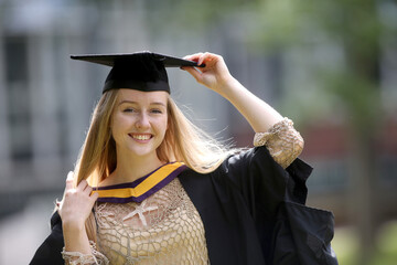 Portrait of a happy woman on her graduation day at university. Education and people.