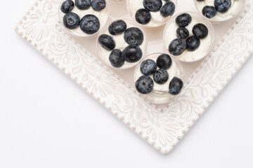 Mini lemon cheesecake cups with blueberries on a white plate