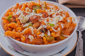 Healthy mackerel and pasta dish garnished with cheese.