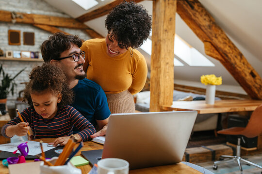 Adorable multiracial family bonding together at home and drawing