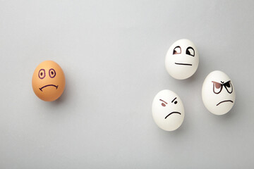 Eggs with different emotions on his face. Easter composition with copy space on grey background. Stop racism