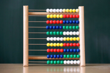 Slide rule, abacus with blackboard, elementary school background. 