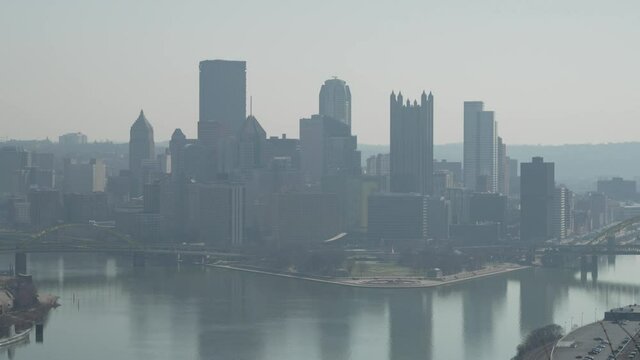A long shot view of the Pittsburgh city skyline on a hazy day in later winter.  	