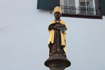 Closeup shot of the statue of St Urban on the ancient fountain from 1448 carrying his name ('Urban-Brunnen'), based on 3rd century Pope Urban I - Blumenrain, downtown Basel, Switzerland