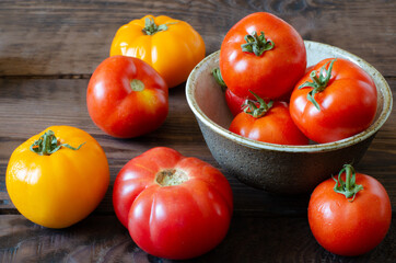 tomatoes in bowl on wooden background. Yellow and red tomatoes.