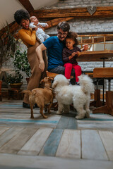 Multiracial family playing with their pets at home