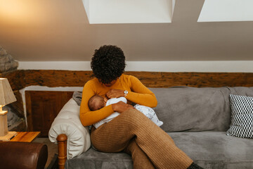 Black mom breastfeeding baby at home