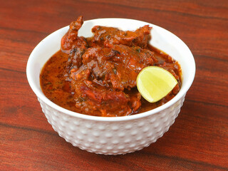 Indian Butter Chicken or Murgh Makhani in a bowl over a wooden rustic background. selective focus