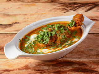 Chicken Masala in a bowl over a wooden rustic background. selective focus