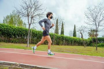 Young man running on the track in the park