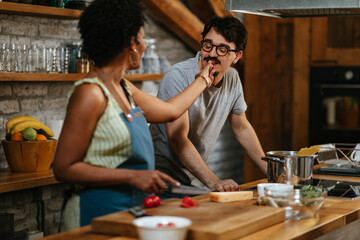 Multiracial couple in the kitchen preparing food