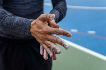 close up of hands with climbing chalk