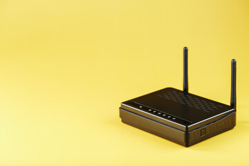 Wi-Fi router in black on a yellow background with free space.