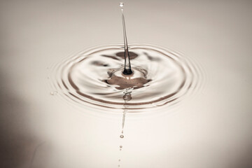 View macro of drops making circles on water surface isolated on background.