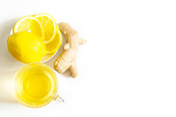 Medicinal tea in a cup, ginger, lemon-strengthen the immune system in the cold season. Vitamin drink for health and ingredients on a white background. Copy space, flatly