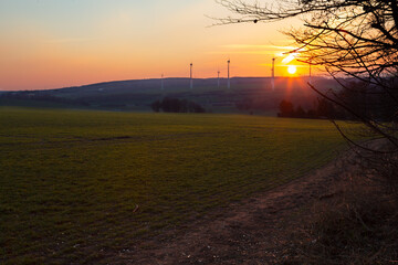 Beautiful winter at the country field with hight power wind turbines at the top of the hill.