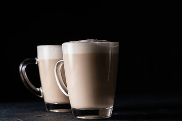 Two cups of chai latte, hot tea drink with foamed milk