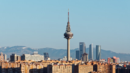 Panoama of the business district in northern part of Madrid city. Snow covered mountains visible in the distance of this image taken just after sunrise.