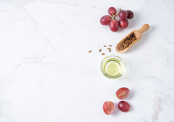 Flat lay is made of natural grape seed oil on white marble background. Natural cosmetics, healthy life style