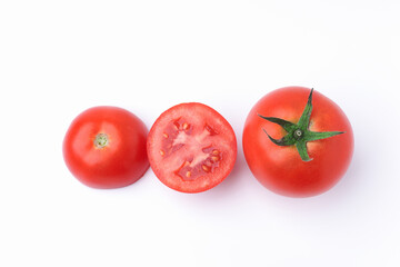 One fresh red tomato, and one tomatoes cut in half top view flat lay isolated on a white background.