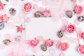 Flatlay Easter composition with quail eggs, feathers and roses