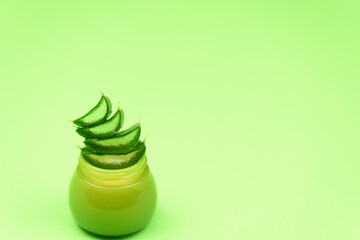 Aloe Vera Gel. Jar of aloe vera cream on a green background. Organic cosmetics.