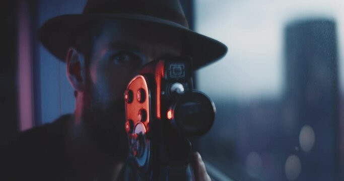 Filmmaker with a hat and a film camera in his hands 