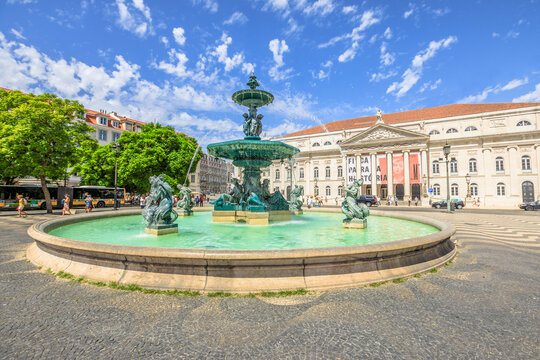 Lisbon, Portugal - August 26, 2017: baroque fountain on popular Praca Dom Pedro IV or Rossio Square in Lisbon downtown, Portugal, Europe. The National Theater D. Maria on background. Sunny day.