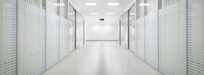Empty bank office corridor with glass walls and doors