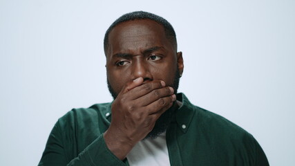 Portrait african man checking breath freshness in studio. Guy preparing for date
