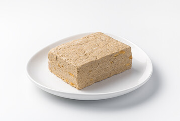 Halva close-up on a light plate isolated on a white background.