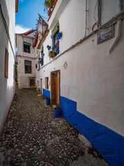 Fototapeta premium narrow street in the old town of Granada with Old Albaicin buildings, Spain